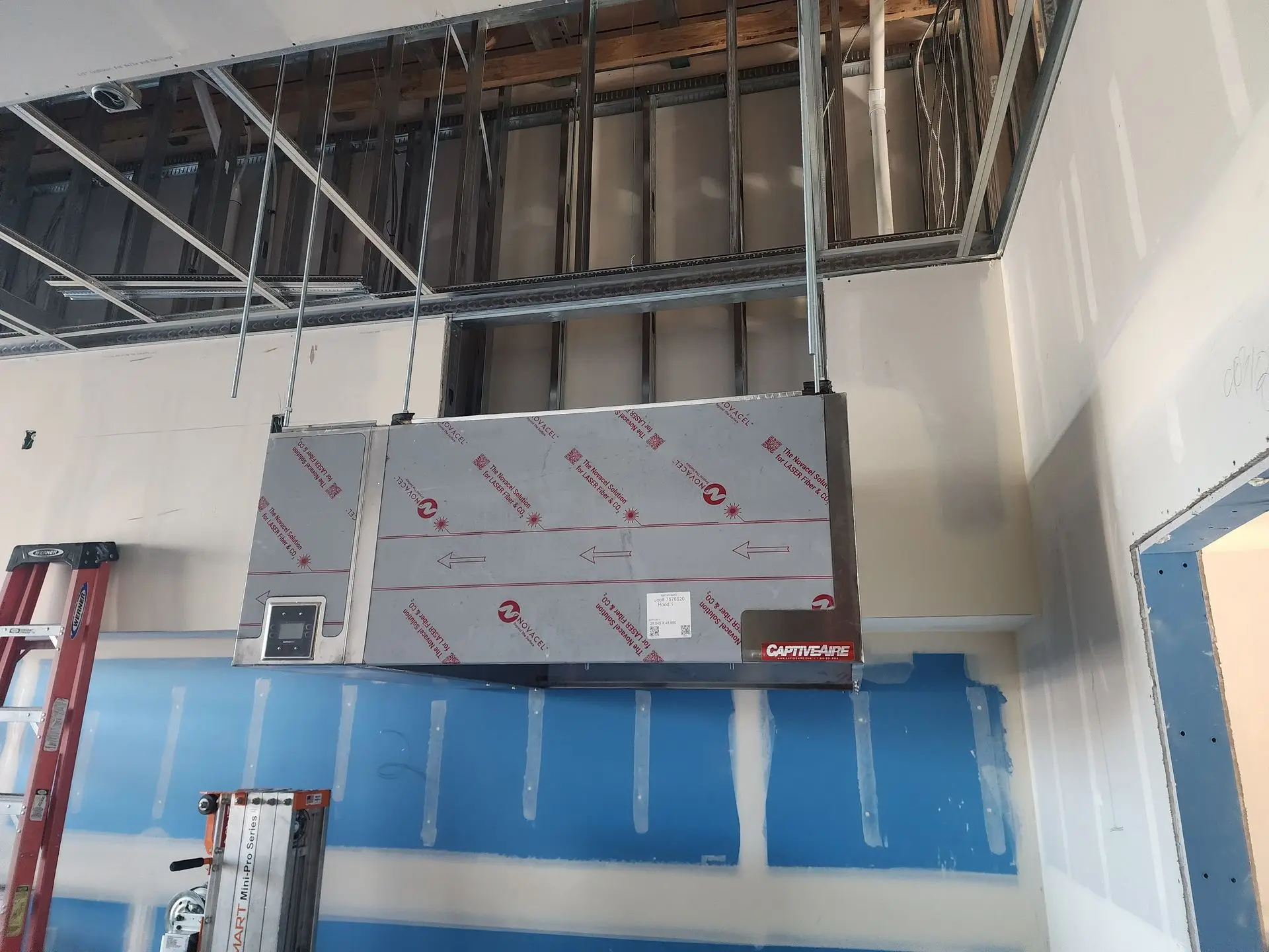 Commercial kitchen hood being installed during a tenant improvement