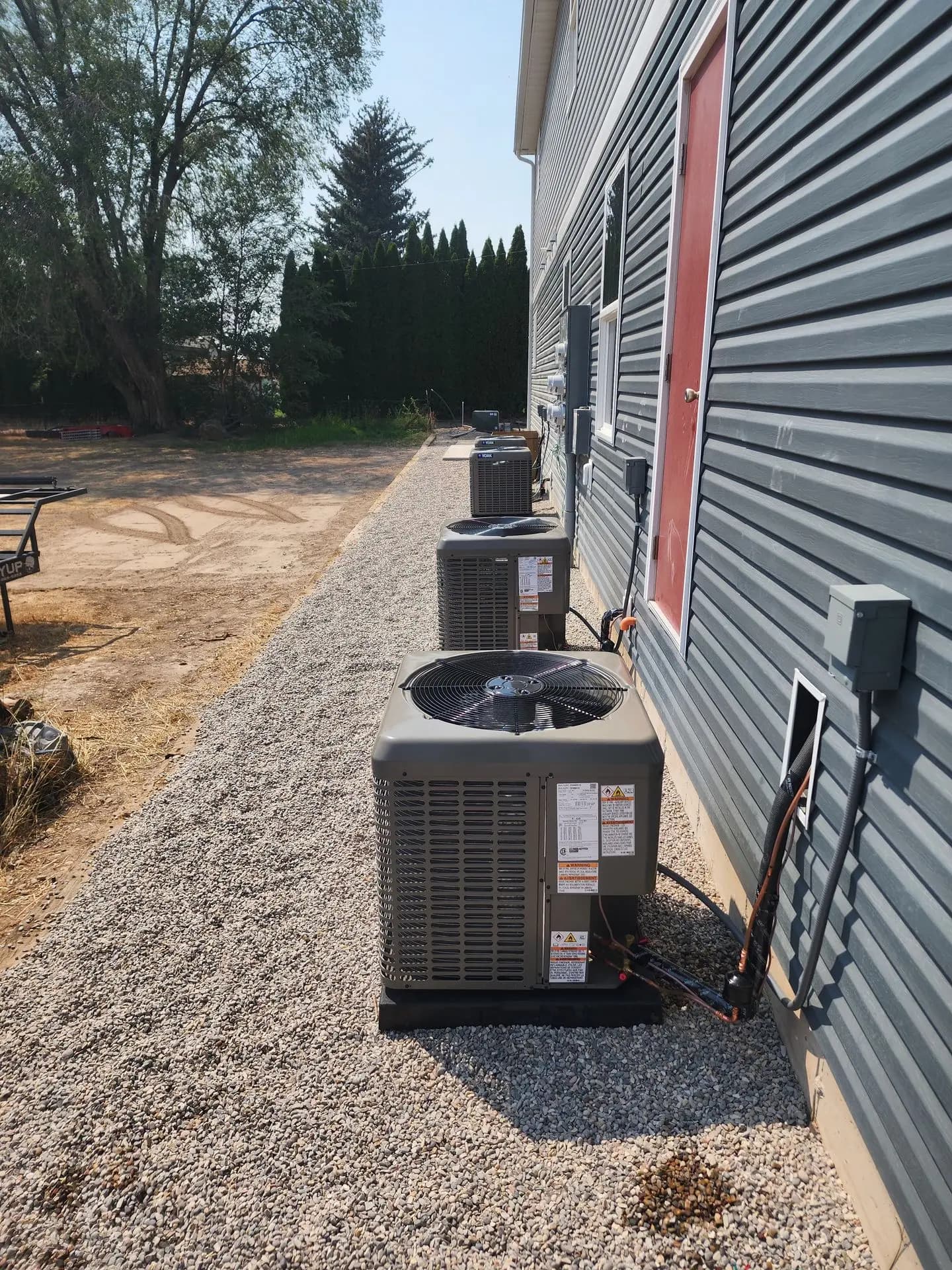 Row of three new condensers along a multi-unit building