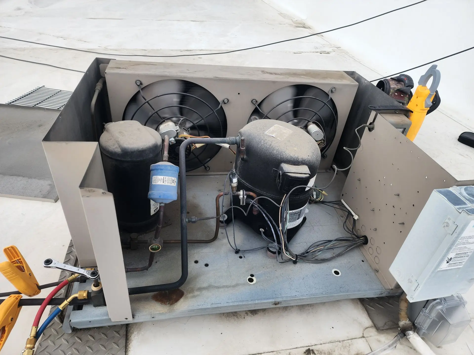 Commercial condensing unit opened for service on a rooftop