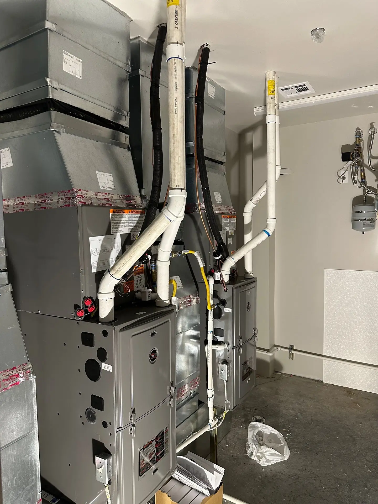 Two new furnaces with custom plenums installed in a garage mechanical space